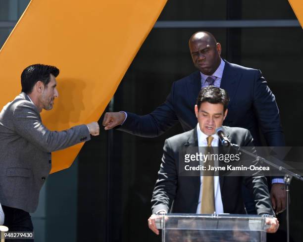President and co-owner Tom Penn of the Los Angeles FC speaks at the podium as owners Magic Johnson and Nomar Garciaparra fist bump in the background...