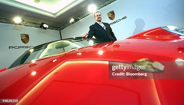 Porsche AG Chief Executive Wendelin Wiedekind poses behind a Porsche Carrera S Cabrio automobile at the company's year earnings press conference in...