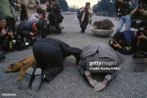 La population japonaise pleure l'empereur Hiro-Hito en pleine rue sous l'objectif des photographes le 7 janvier 1989 à Tokyo, Japon.