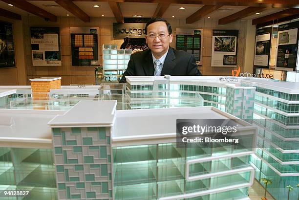 Leong Hoy Kum, managing director and chief executive officer of Mah Sing Group Bhd., poses for a photograph with a scale model of the company's...