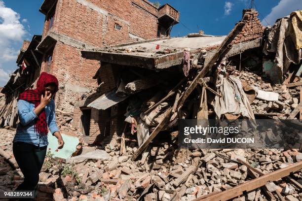 Femme avec un foulard passant devant les gravats d'une maison détruite, après le tremblement de terre, le 3 mai 2015, village de Khokana, vallée de...