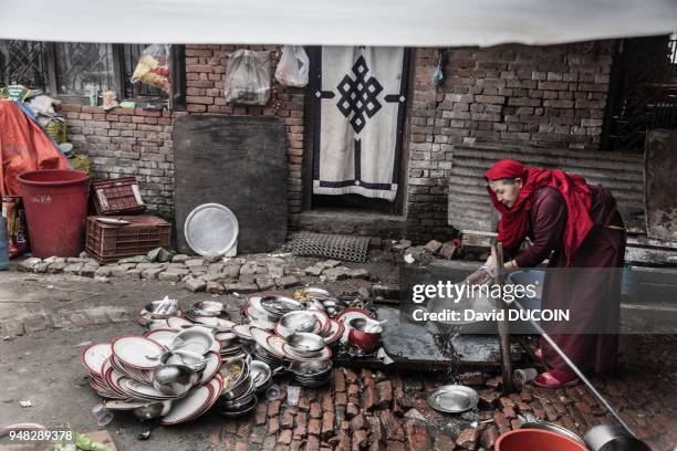 Une femme faisant la vaisselle dans une cour du monastère de Ka-Nying Shedrub Ling, après le tremblement de terre, le 6 mai 2015, à Bodnath,...