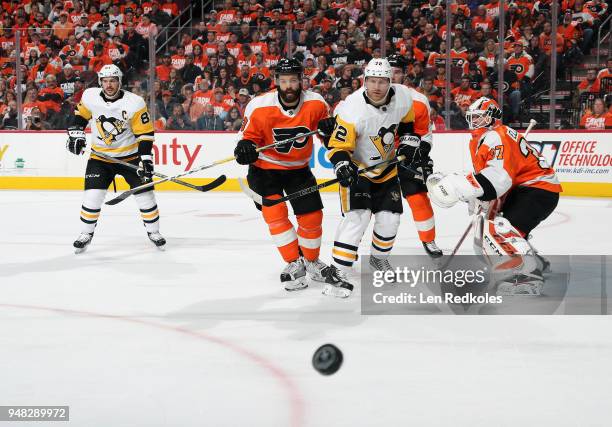 Radko Gudas and Brian Elliott of the Philadelphia Flyers reacts to the airborne puck against Patric Hornqvist and Sidney Crosby of the Pittsburgh...