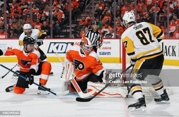 Sidney Crosby of the Pittsburgh Penguins takes a shot on goal against Brian Elliott and Ivan Provorov of the Philadelphia Flyers in Game Three of the...