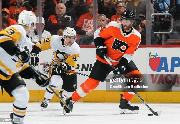 Sean Couturier of the Philadelphia Flyers skates the puck against Conor Sheary of the Pittsburgh Penguins in Game Three of the Eastern Conference...