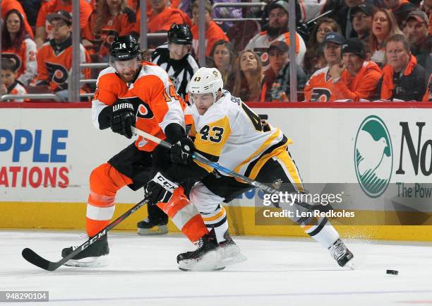 Sean Couturier of the Philadelphia Flyers passes the puck against Conor Sheary of the Pittsburgh Penguins in Game Three of the Eastern Conference...