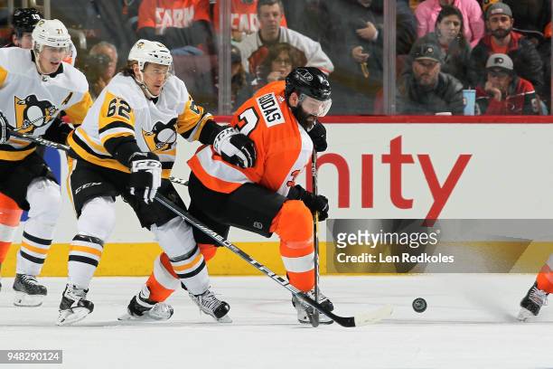 Radko Gudas of the Philadelphia Flyers battles for the loose puck against Carl Hagelin and Evgeni Malkin of the Pittsburgh Penguins in Game Three of...