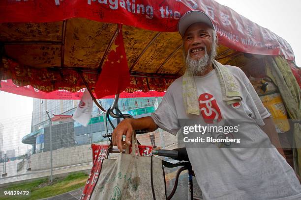 Chen Guanming, a 56 year-old farmer who has ridden over 40,000 milies over seven years, poses for a portrait in Beijing, China, on Thursday, July 31,...