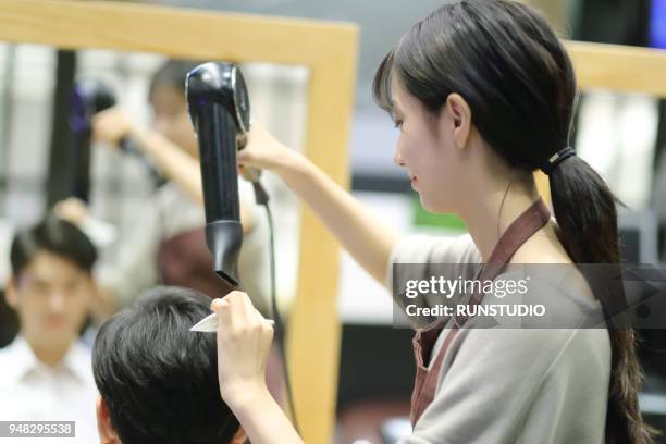 hairdresser drying customer's hair in salon - hand holding hair dryer stock pictures, royalty-free photos & images