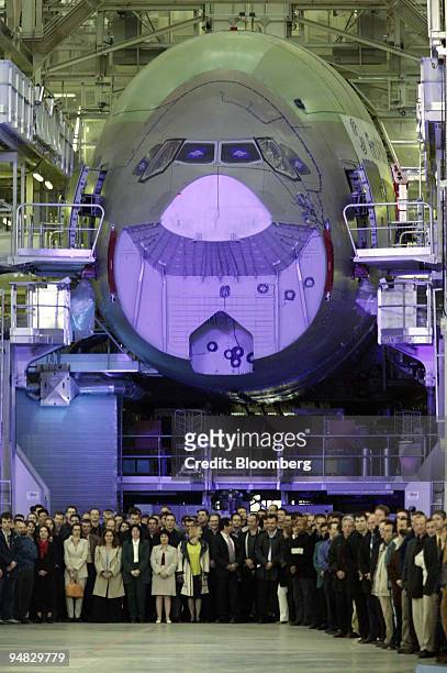 Workers gather in front of the nose cone of an Airbus A380 at the opening ceremony for the new final-assembly plant at Airbus's Toulouse, France,...