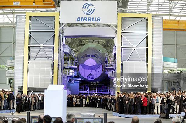 Workers gather in front of the nose cone of an Airbus A380 at the opening ceremony for the new final-assembly plant at Airbus's Toulouse, France,...