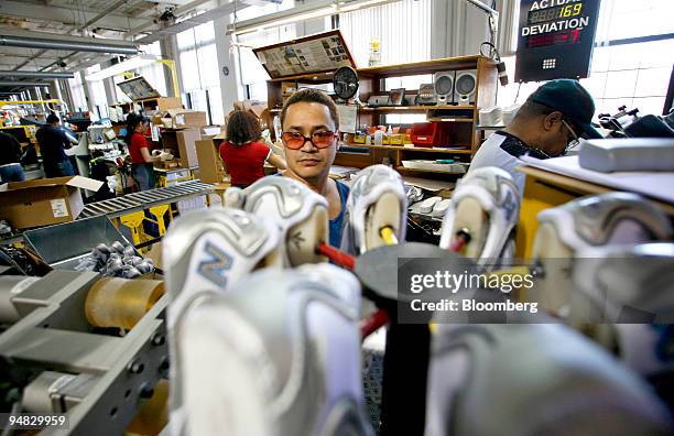 Alcie Hidalgo places insoles in athletic shoes during their assembly in a New Balance facility in Lawrence, Massachusetts Monday, March 6, 2006.