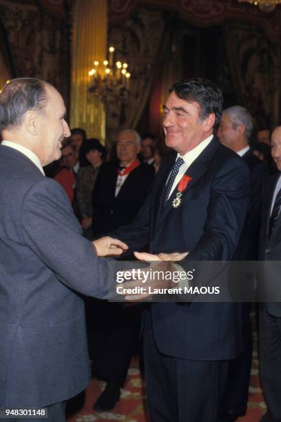 Le président François Mitterrand décore l'auteur, journaliste et cinéaste Claude Lanzmann au Palais de l'Elysée le 11 mars 1986 à Paris, France.