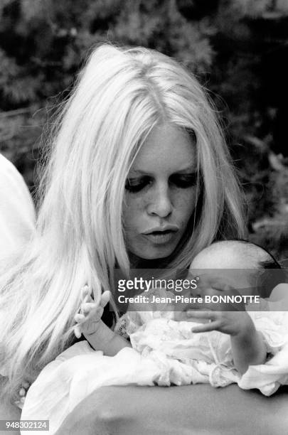 Brigitte Bardot tenant un bébé dans ses bras en mai 1967 à Rome, Italie.