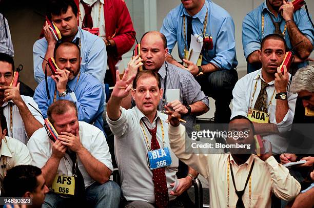 Traders signal orders at the Brazilian Bolsa de Mercadorias e Futuros, or Brazilian Mercantile and Futures Exchange , in Sao Paulo, Brazil, on...