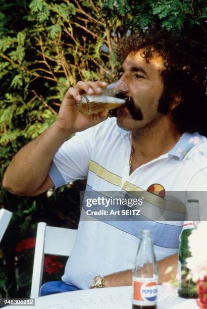 Ion Tiriac buvant un verre de bière.