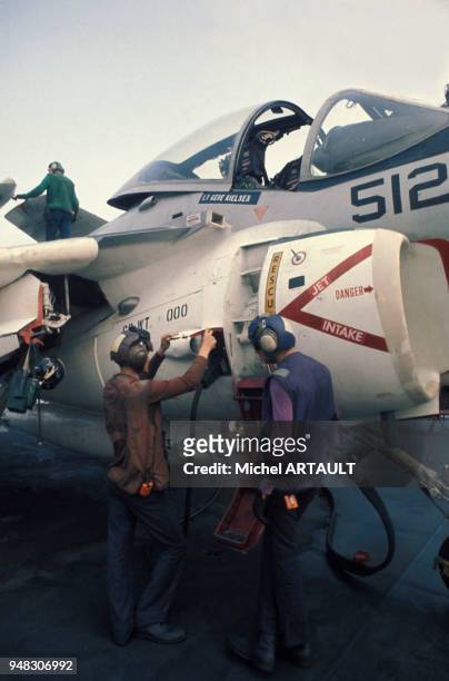 Mécaniciens travaillant sur un avion de chasse, sur le pont du porte-avions USS Nimitz de la marine américaine, le 4 septembre 1975.