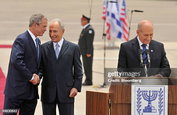 President George W. Bush, left, shakes hands with Shimon Peres, Israel's president, center, as Ehud Olmert, Israel's prime minister speaks during the...