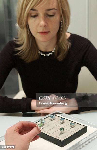 Astrid Walsh, manager at Boodle & Dunthorne Jewelers helps a customer choose a ring from a selection in the store at the Royal Exchange in London,...