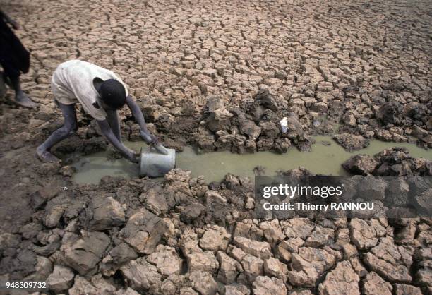 Enfant prenant de l'eau dans le lit asséché du lac Tchad pendant une sécheresse au Niger, en novembre 1984.