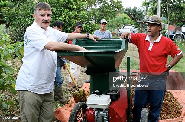 Noel Janetski, president of Mars Inc.'s PT Mars Symbioscience Indonesia, left, demonstrates the operation of a composting machine custom designed by...