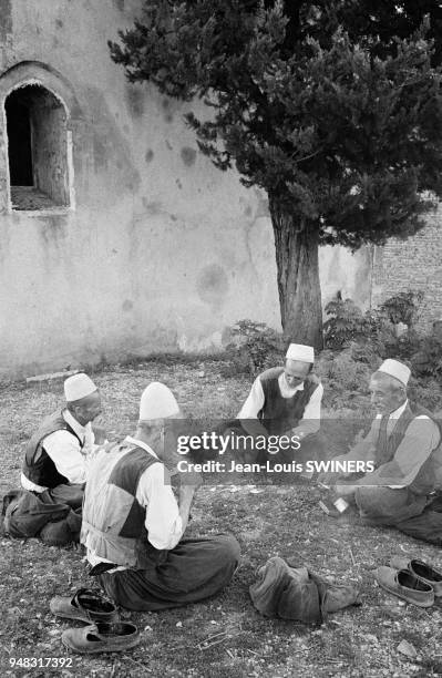 Hommes âgés discutant dans un jardin à Shkodër, en août 1964, Albanie.