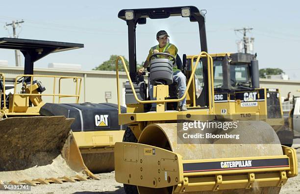 An employee at the Holt Cat dealership in Irving, Texas, moves a compactor on Monday, May 3, 2004. U.S. Companies including Caterpillar Inc. Have...