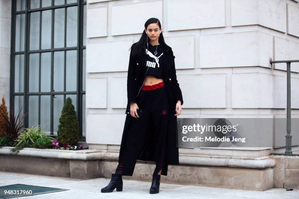 Dutch model Nikki Vonsee listens to music on her iPhone and wears silver eyemakeup from the Delpozo show and an all black outfit including a coat,...