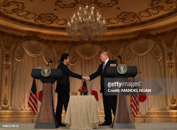 Japan's Prime Minister Shinzo Abe shakes hands with US President Donald Trump at the close of a joint press conference at Trump's Mar-a-Lago estate...