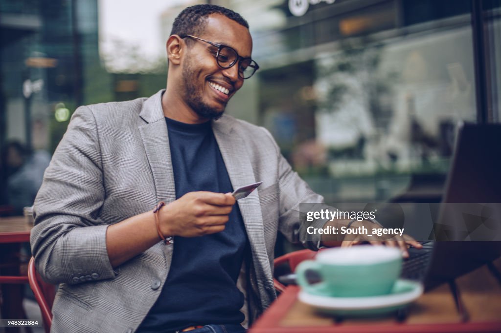 Man using laptop in coffee shop