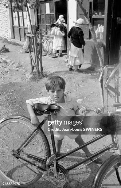 Enfant gardant un vélo sur le marché de Shkodër, en 1964, Albanie.