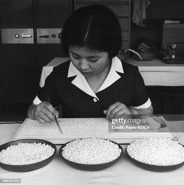 Ouvrière triant les perles pour la fabrication des colliers dans une entreprise de culture industrielle de perles à Shima, dans la baie d'Ago, en...