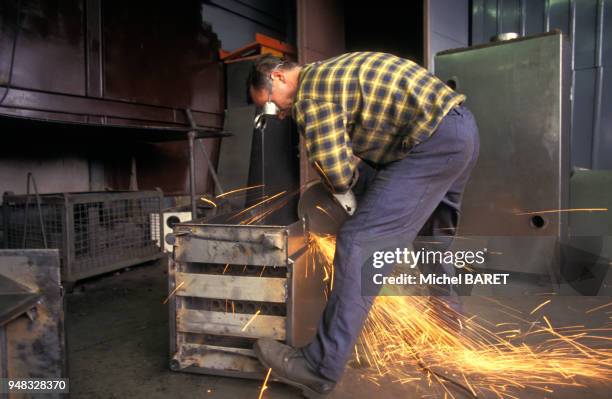 Ouvrier sciant du métal dans l'usine Elgaz de Gdynia, en juin 1989, Pologne.