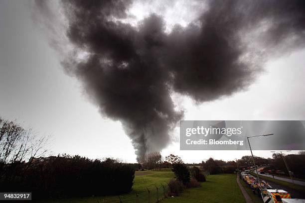 Emergency services seen parked in a closed road as an acrid smoke plume from the fires still burning at the oil depot in Hemel Hempstead moves...