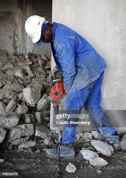 Elabed Bibel, a Bouygues employee, uses a drill on a Bouygues construction site in Paris, France, on Wednesday, Aug. 27, 2008. Bouygues reports its...