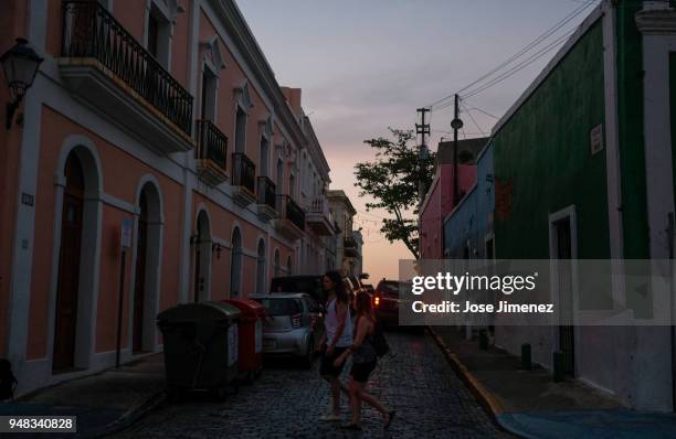 Tourists walk along San Sebastian street on April 18, 2018 in Old San Juan, Puerto Rico as a major failure knocked out the electricity in Puerto Rico...