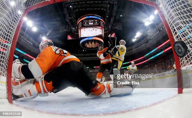 Brian Elliott of the Philadelphia Flyers is unable to stop a shot from Evgeni Malkin of the Pittsburgh Penguins as Andrew MacDonald of the...