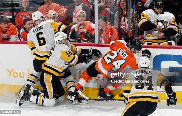 Jamie Oleksiak and Riley Sheahan of the Pittsburgh Penguins collide along the boards with Matt Read of the Philadelphia Flyers while pursuing the...