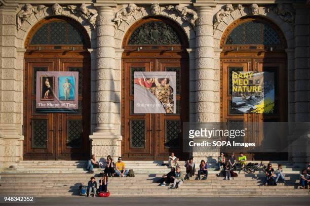 People enjoy the sun light in front of the Museum of Fine Arts in Vienna.