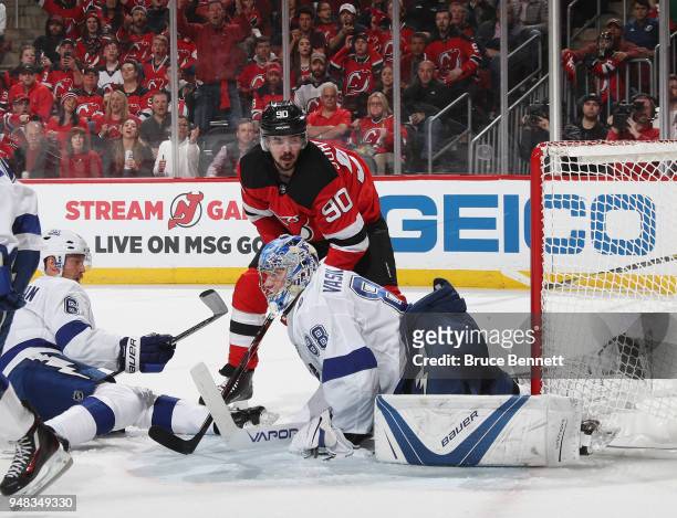 Andrei Vasilevskiy of the Tampa Bay Lightning makes the save and knocks the net off the pegs as Marcus Johansson of the New Jersey Devils looks for a...