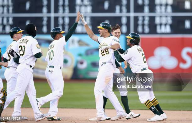 Matt Olson of the Oakland Athletics is congratulated by teammates after he hit the game winning single in the bottom of the 14th inning to beat the...