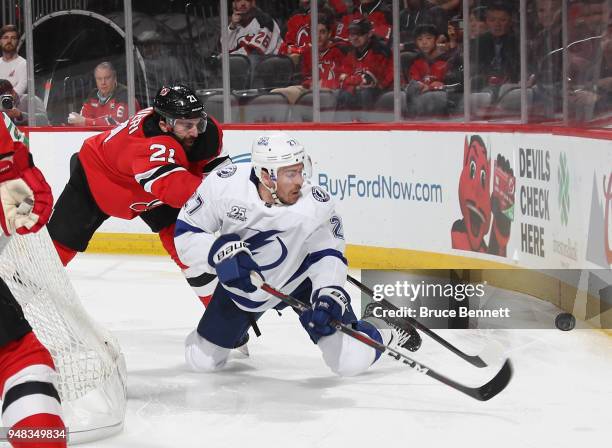 Ryan McDonagh of the Tampa Bay Lightning shoots the puck away from Kyle Palmieri of the New Jersey Devils during the second period in Game Four of...