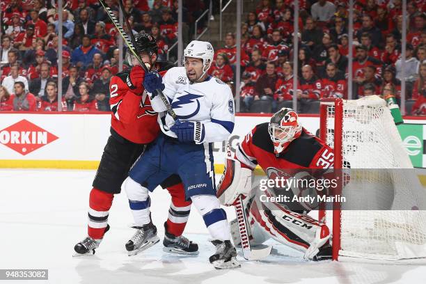 Ben Lovejoy and Cory Schneider of the New Jersey Devils defend the net against Tyler Johnson of the Tampa Bay Lightning in Game Four of the Eastern...