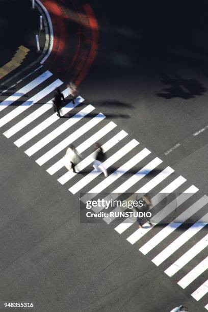 high angle view of pedestrians crossing shibuya street - strisce pedonali foto e immagini stock