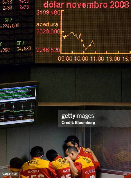 Traders speak in a corner at the Bolsa de Mercadorias e Futuros, or Brazilian Mercantile and Futures Exchange , in Sao Paulo, Brazil, on Friday, Oct...