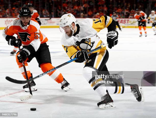 Bryan Rust of the Pittsburgh Penguins takes the puck as Shayne Gostisbehere of the Philadelphia Flyers defends in the third period of Game Four of...