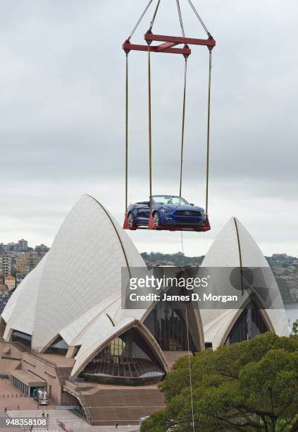 Ford Mustang convertible is lifted onto a rooftop near the Opera House on December 28, 2014 in Sydney, Australia. Launched skyward in the early hours...