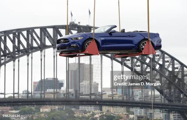 Ford Mustang convertible is lifted onto a rooftop near the Opera House on December 28, 2014 in Sydney, Australia. Launched skyward in the early hours...