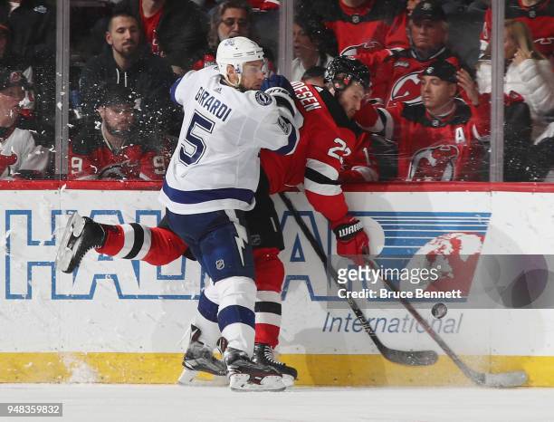 Dan Girardi of the Tampa Bay Lightning hits Stefan Noesen of the New Jersey Devils into the boards during the third period in Game Four of the...