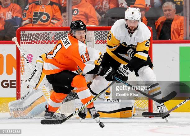 Travis Konecny of the Philadelphia Flyers and Brian Dumoulin of the Pittsburgh Penguins fight for the puck in the third period in Game Four of the...